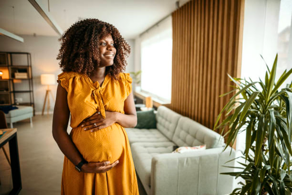 Beautiful pregnant woman relaxing at home, symbolizing hope and joy while exploring surrogacy cost in Nigeria.